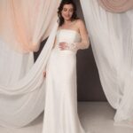 Abito da sposa Emilia con corpetto in duchesse, gonna in cady svasata, look moderno ed elegante, guanti in pizzo come accessorio