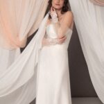 Abito da sposa Emilia con corpetto in duchesse, gonna in cady svasata, look moderno ed elegante, guanti in pizzo come accessorio