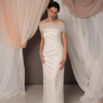 Abito da sposa modello Bustier in duchesse di seta con spacco, bustier dritto e stola in tulle drappeggiato sulle spalle, stile elegante e moderno