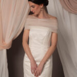 Abito da sposa modello Bustier in duchesse di seta con spacco, bustier dritto e stola in tulle drappeggiato sulle spalle, stile elegante e moderno