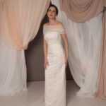Abito da sposa modello Bustier in duchesse di seta con spacco, bustier dritto e stola in tulle drappeggiato sulle spalle, stile elegante e moderno