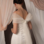 Abito da sposa modello Bustier in duchesse di seta con spacco, bustier dritto e stola in tulle drappeggiato sulle spalle, stile elegante e moderno