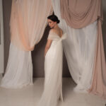 Abito da sposa modello Bustier in duchesse di seta con spacco, bustier dritto e stola in tulle drappeggiato sulle spalle, stile elegante e moderno